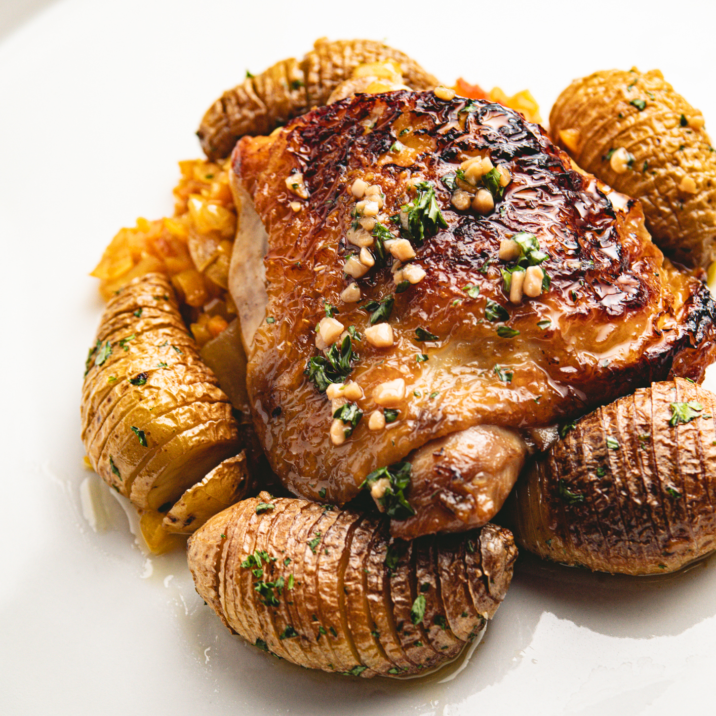 CHICKEN THIGHS WITH PISTO AND FINGERLING HASSELBACKS.